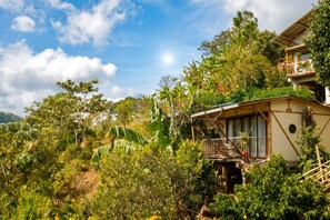 Un bungalow con balcón, rodeado de exuberante vegetación tropical.