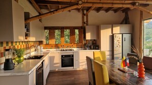 Una cocina moderna con una isla central, vigas de madera y vistas al exterior.