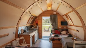 A cozy, compact interior with a kitchenette, a bed, and a seating area.