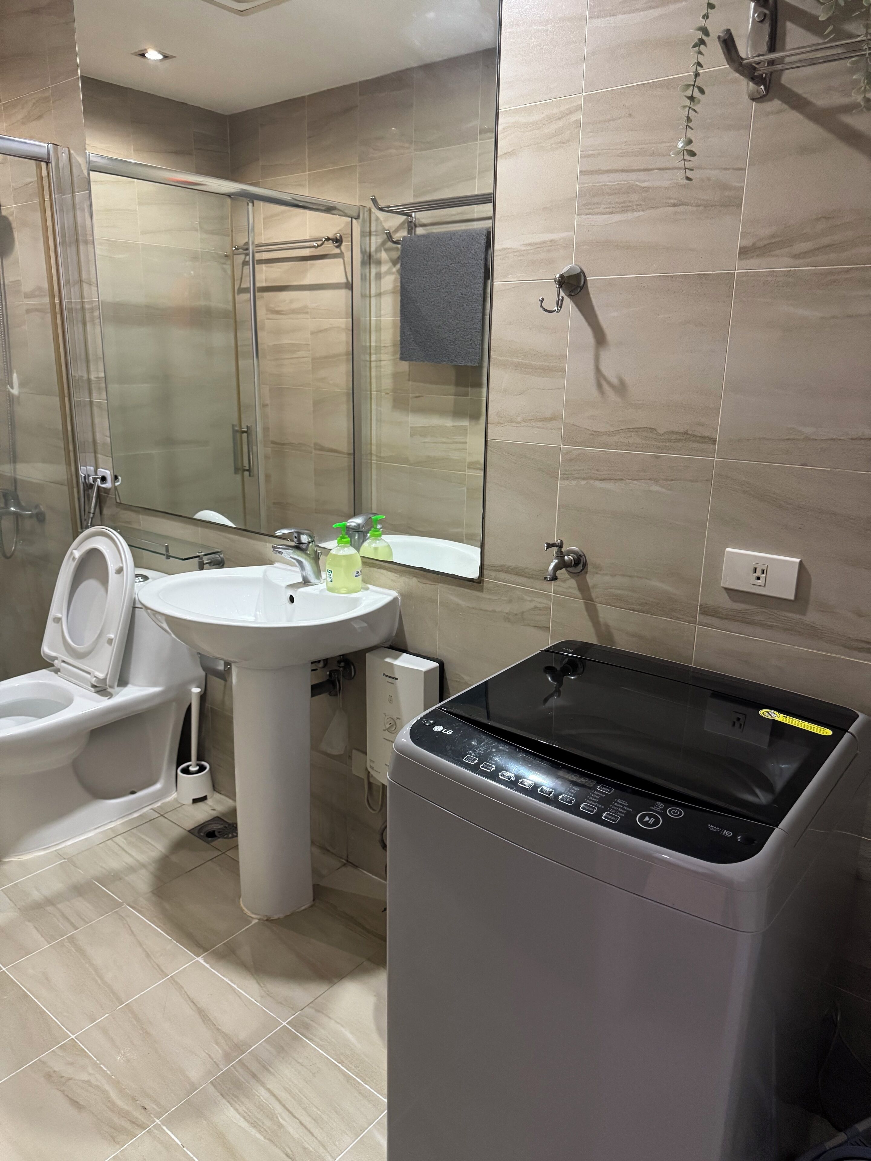 A modern bathroom with a toilet, sink, and glass shower enclosure.