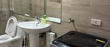 A modern bathroom with a toilet, sink, and glass shower enclosure.
