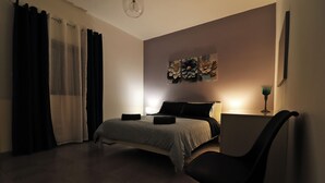 Ein Schlafzimmer mit Bett, Stuhl, Schreibtisch und Wandbild.