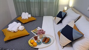 A neatly made bed with pillows, a bedside table with a lamp, and a tray with croissants, fruit, and a drink. - Apartment with self- check in, free private parking, WI-FI in brilliant Zagreb (Zagreb)
