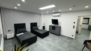 A modern bedroom with two beds, a TV, and a small kitchenette. - Modern Apartments Gelsenkirchen highway A42 and A2 vacation apartment (Gelsenkirchen)