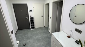 A bathroom with a white vanity, a round mirror, and a potted plant. - Modern Apartments Gelsenkirchen highway A42 and A2 vacation apartment (Gelsenkirchen)