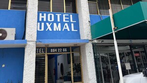 Un hotel con facciata blu, diversi balconi e un numero di telefono ben visibile.