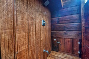 Uma cabana de madeira com porta, janela e puxador de metal.