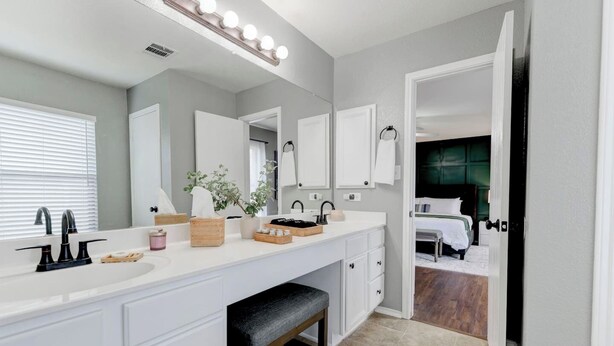 Un bagno moderno con un ampio lavabo, due lavandini e una panca.