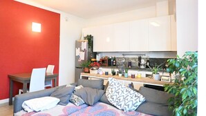 A modern living room with a grey sofa, a dining table with chairs, and a kitchen area with white cabinets and various items on the counter. - CN004 - Cesenatico, new penthouse with terrace and Jacuzzi (Cesenatico)