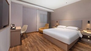 A modern hotel room with a large bed, a desk with a chair, a television, and a bedside table with a lamp. - Peace & Ease Hotel (Suzhou Jinji Lake Expo Center) (Suzhou)