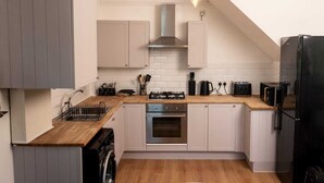 A compact kitchen with a built-in oven, a sink, and a dishwasher.
