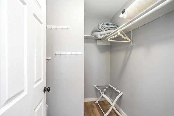 A small, neatly organized closet with hanging space and a drying rack. - Downtown Riverside Condo with Pool. (Nashville)