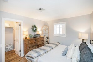 Une chambre à coucher avec un lit, une commode et une petite fenêtre.