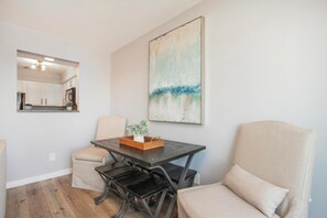 Un coin repas avec une table, des chaises et un tableau accroché au mur.