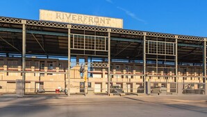 A large industrial building with a sign reading "RIVERFRONT condominiums." - Downtown Riverside Condo with Pool. (Nashville)
