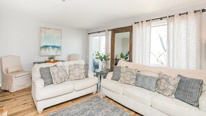 A living room with two sofas, a chair, and a rug. - Downtown Riverside Condo with Pool. (Nashville)