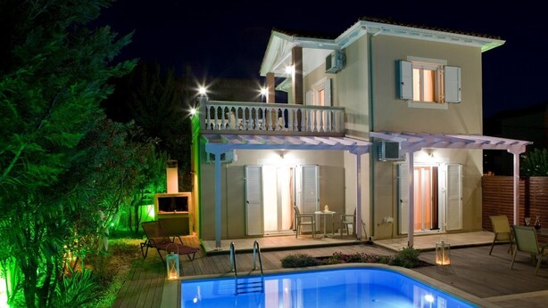 Ein zweistöckiges Haus mit Swimmingpool, Gartenmöbeln und einer überdachten Terrasse.