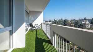 A balcony with a clear view of the cityscape, a small table, and a chair. - Appartement Mi-Luna - Welkeys (Tassin-la-Demi-Lune)