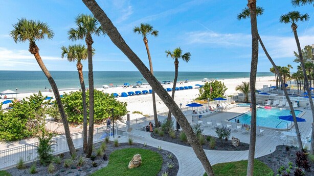 A resort with a pool, lounge chairs, and a beach view. - Beachfront 3 bedroom with Amazing Views! (Indian Shores)