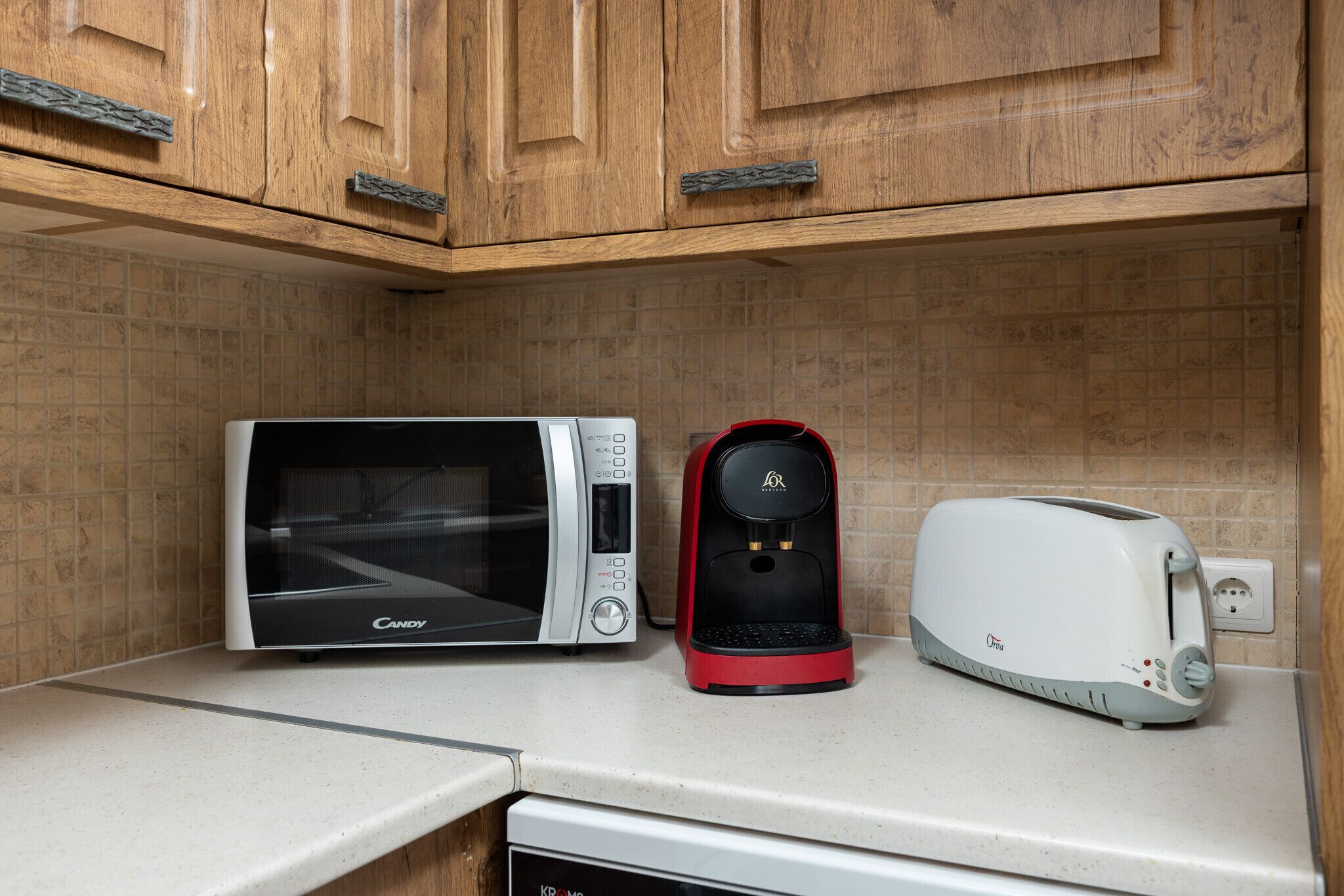 A kitchen with a microwave, coffee maker, and toaster on the countertop.