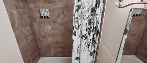 A bathroom with a bathtub, toilet, sink, and shower curtain.