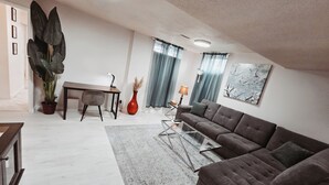 Una sala moderna con un sof á, una mesa de centro, una mesa de comedor y una planta en maceta.