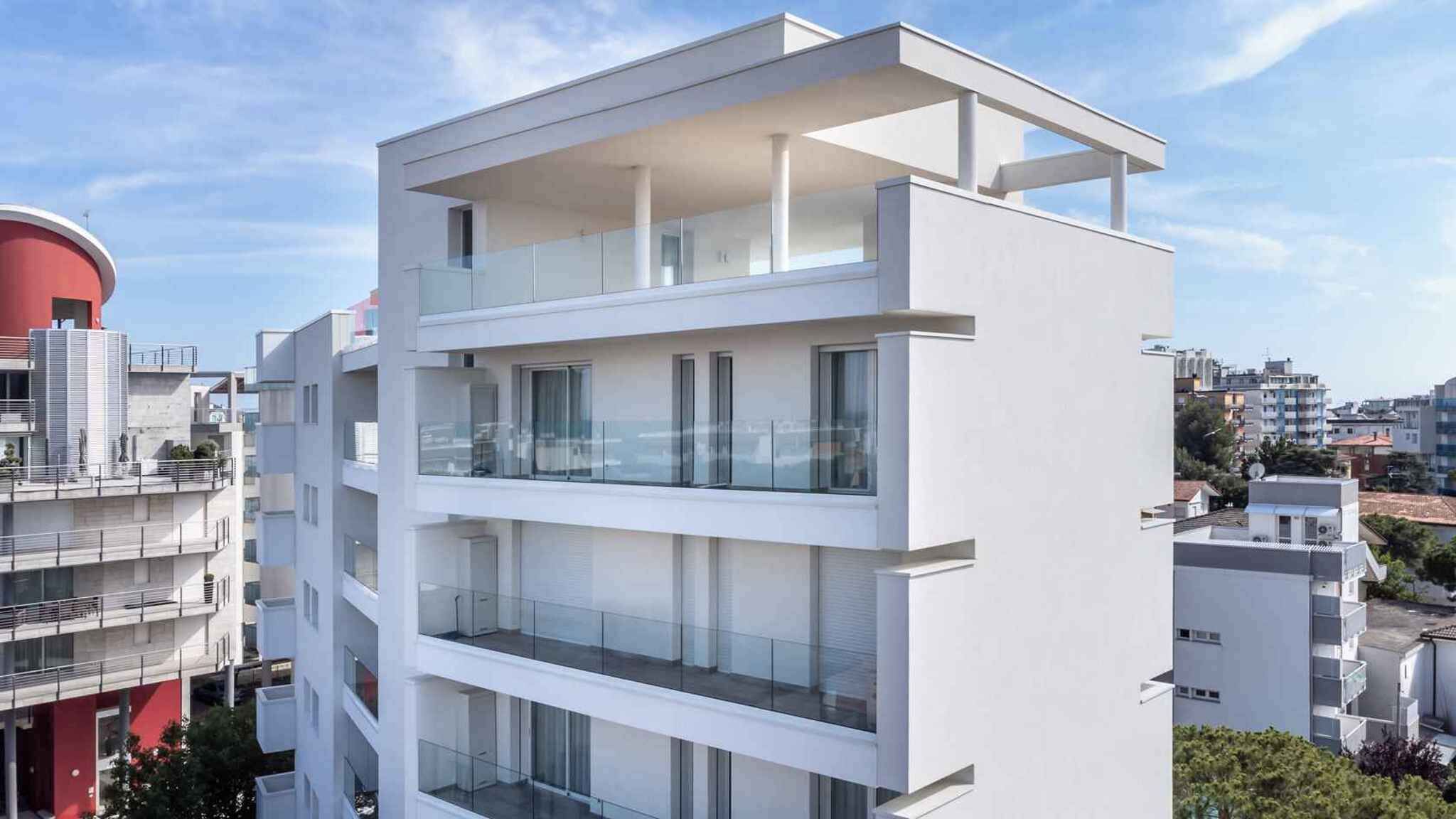 A modern multi-story building with balconies and large windows.