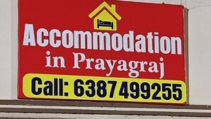 A red sign with white and yellow text advertising accommodation in Prayagraj, including a contact number. - Accommodation In Prayagraj (Prayagraj)