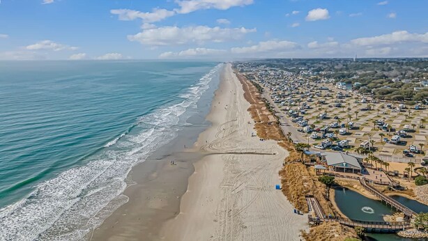 Una zona costera con playa, puerto deportivo y una zona residencial densamente poblada.
