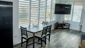 A modern dining area with a large table, chairs, and a television. - Spacious 6-bedroom villa in gorgeous Luquillo with WiFi, AC (Luquillo)
