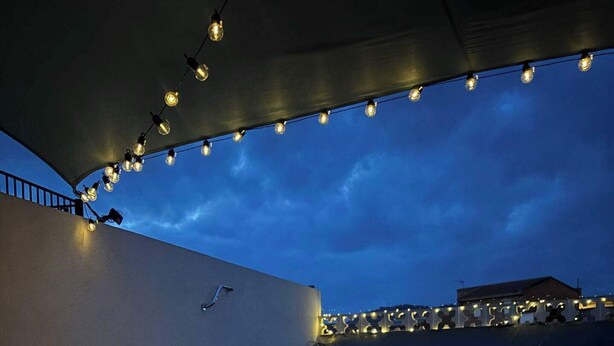 A rooftop terrace with string lights, two lanterns, and a patterned rug. - Casasona, Alcaudete,jaen,housesleeps4- Pool-patio (Alcaudete)