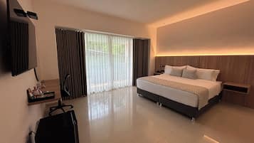 Una habitación de hotel moderna con una cama grande, un escritorio, una silla y un televisor montado en la pared.
