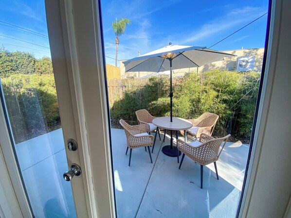 Enjoy the serene view from your patio, surrounded by lush greenery and a tall palm tree.