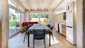 A covered patio with a dining table, chairs, a red sofa, and a white refrigerator. - Holiday Home 'Buontempo' with Private Pool, Wi-Fi and Air Conditioning (Francavilla Fontana)