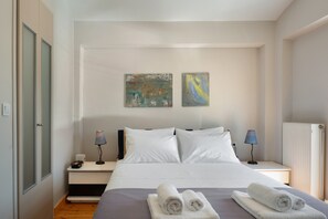 A bedroom with a bed, two bedside lamps, a nightstand, and two abstract paintings on the wall. - First Floor Bedroom 3 with Shared Terrace, Wi-Fi, and Air Conditioning (????????S)