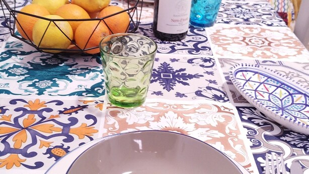 A dining table with a bowl, a wine bottle, and a glass of water. - Apartment 'S'accomodassi - Tra Città E Mare' with Air Conditioning (Avola)