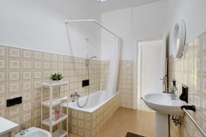 Ein Badezimmer mit Badewanne, Waschbecken und Dusche.