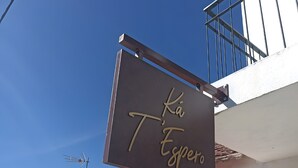 A building with a sign that reads 'Ka T'Espero' and a metal antenna.