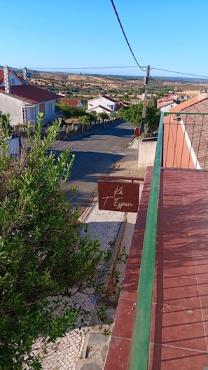 Zona residencial con calle, casas y un cartel que dice 'Ka T'Espero'.