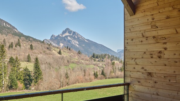 Een houten balkon met uitzicht op de bergen.
