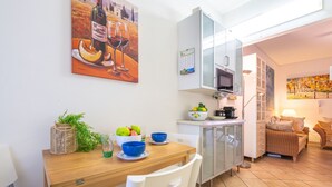 A compact kitchen with a dining area, a microwave, a coffee maker, and a dining table with chairs. - Cozy Holiday Home "Casa Oleandro" in Villasimius – Relaxation & Comfort Near the Sea (Villasimius)
