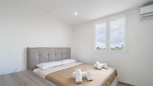 Un dormitorio con cama, mesita de noche y ventana con vistas.