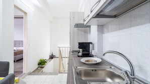 Una cocina moderna con un lavamanos de acero inoxidable, un horno empotrado y una encimera con escurreplatos.