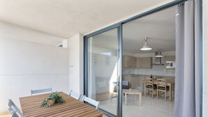 A modern kitchen with wooden cabinets and a dining area with a wooden table and chairs.