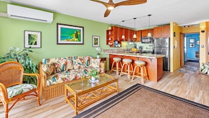 A living room with a sofa, chairs, a coffee table, and a ceiling fan.