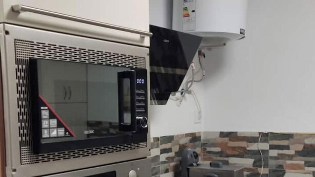 A kitchen with a built-in microwave, oven, and a water dispenser. - Loft Los Olivos in Algar (Algar)