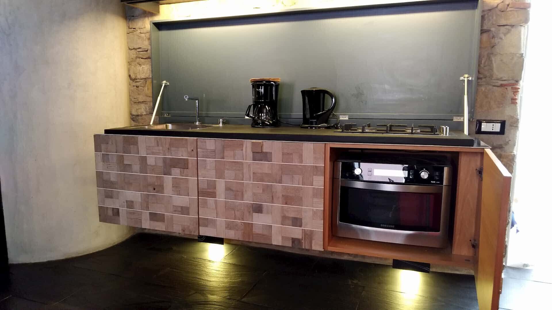 Eine Küche mit Einbauofen, Kaffeemaschine und Spüle.