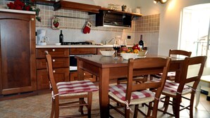 A kitchen with wooden cabinets, a tiled backsplash, and a dining table with chairs.