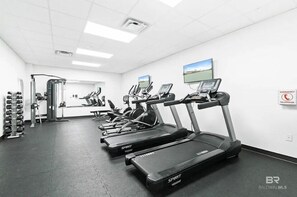 Ein Fitnessstudio mit Laufbändern, Gewichten und Trainingsgeräten.