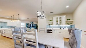 A spacious kitchen with white cabinetry, a central island, and pendant lighting. - PPLM401 Private Heated Pool, Golf Cart Included, Close to the Beach (Port Aransas)